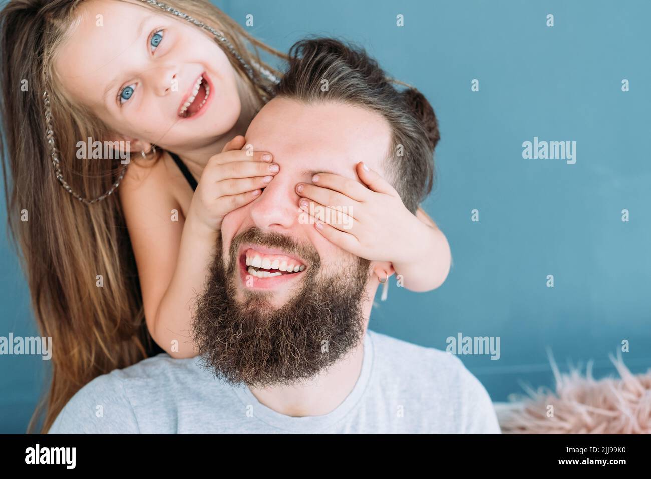 divertente famiglia ragazza tempo libero coprire papà occhi divertimento gioia Foto Stock