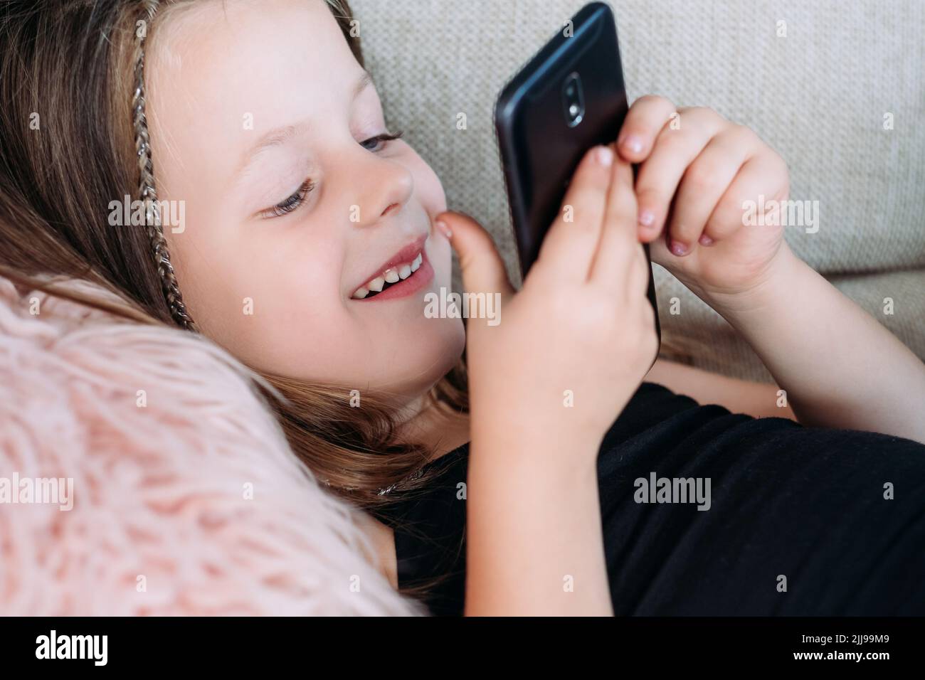 divertimento per bambini sorriso ragazza giocare telefono Foto Stock
