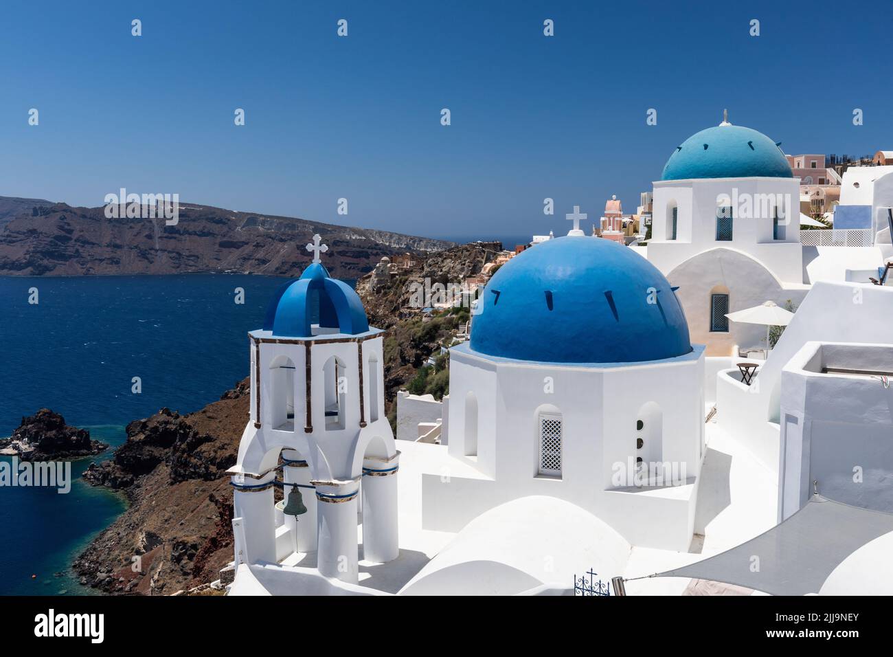 Il famoso punto di riferimento delle cupole blu di Oia si trova ai margini della Caldera a Oia, Santorini, Isole Cicladi, Grecia, Europa Foto Stock