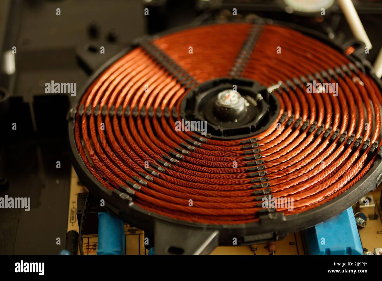 Spirale elettromagnetica di un fornello ad induzione. Parti per cucine a induzione. Elemento riscaldante per un fornello a induzione. Serpentina di riscaldamento di un cuoco a induzione Foto Stock