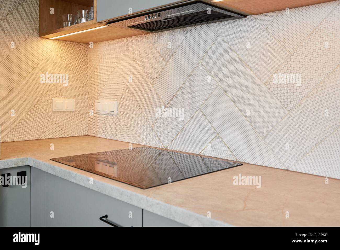 Cucina interna con piano cottura a induzione e mobili in legno, moderno apparecchio da cucina Foto Stock