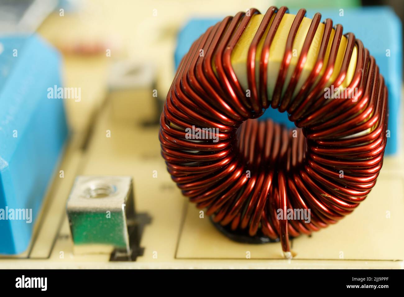 Dettagli elettronici bobina su scheda a circuito stampato. Induttore con filo di rame, trasformatore di isolamento su circuito stampato. Foto Stock
