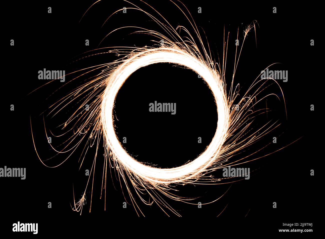 Luce circolare e scintille scintillanti con percorsi esterni scintillanti realizzati utilizzando il bastone scintillante. Sembra un buco nero concettuale e la luce intorno ad esso. Foto Stock