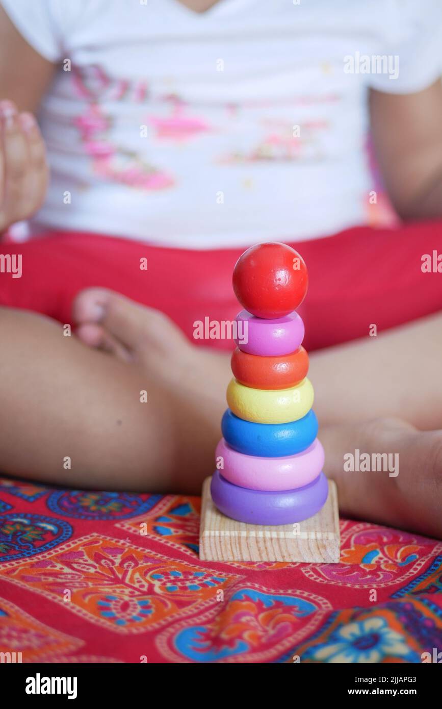Bambino che gioca con i giocattoli del bambino sul letto, concetto di sviluppo del bambino. Foto Stock