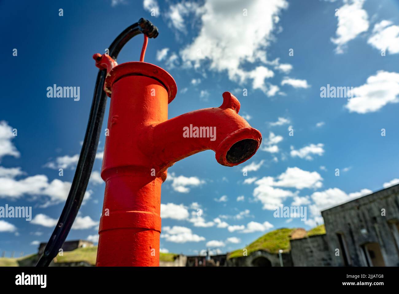Guardare in verticale la vecchia pompa dell'acqua rossa Foto Stock