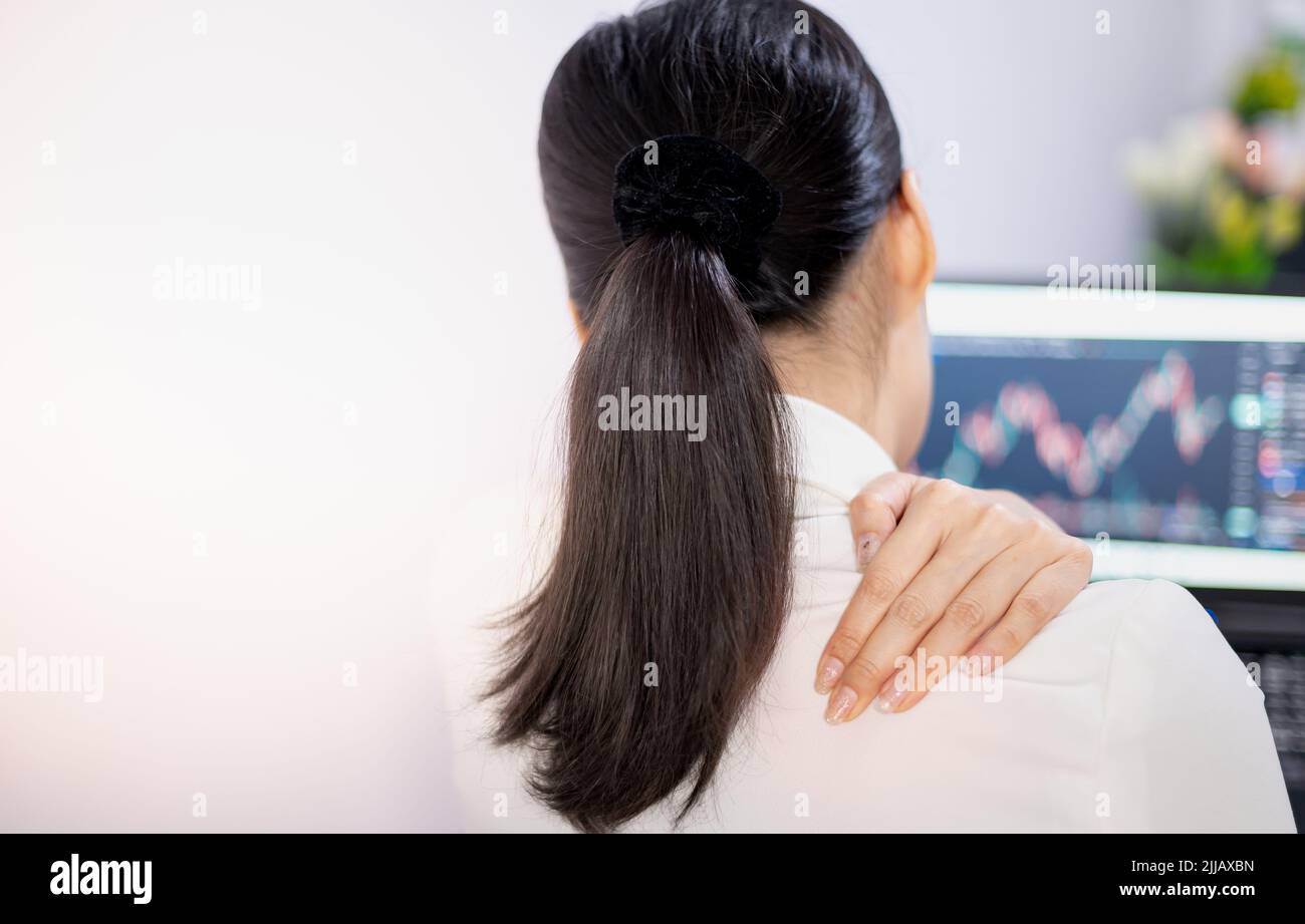 I giovani asiatici sentono dolore dal lavoro, mentre si siedono di fronte a un computer portatile nella loro casa. Concetto di sindrome da ufficio della donna che lavora. Foto Stock