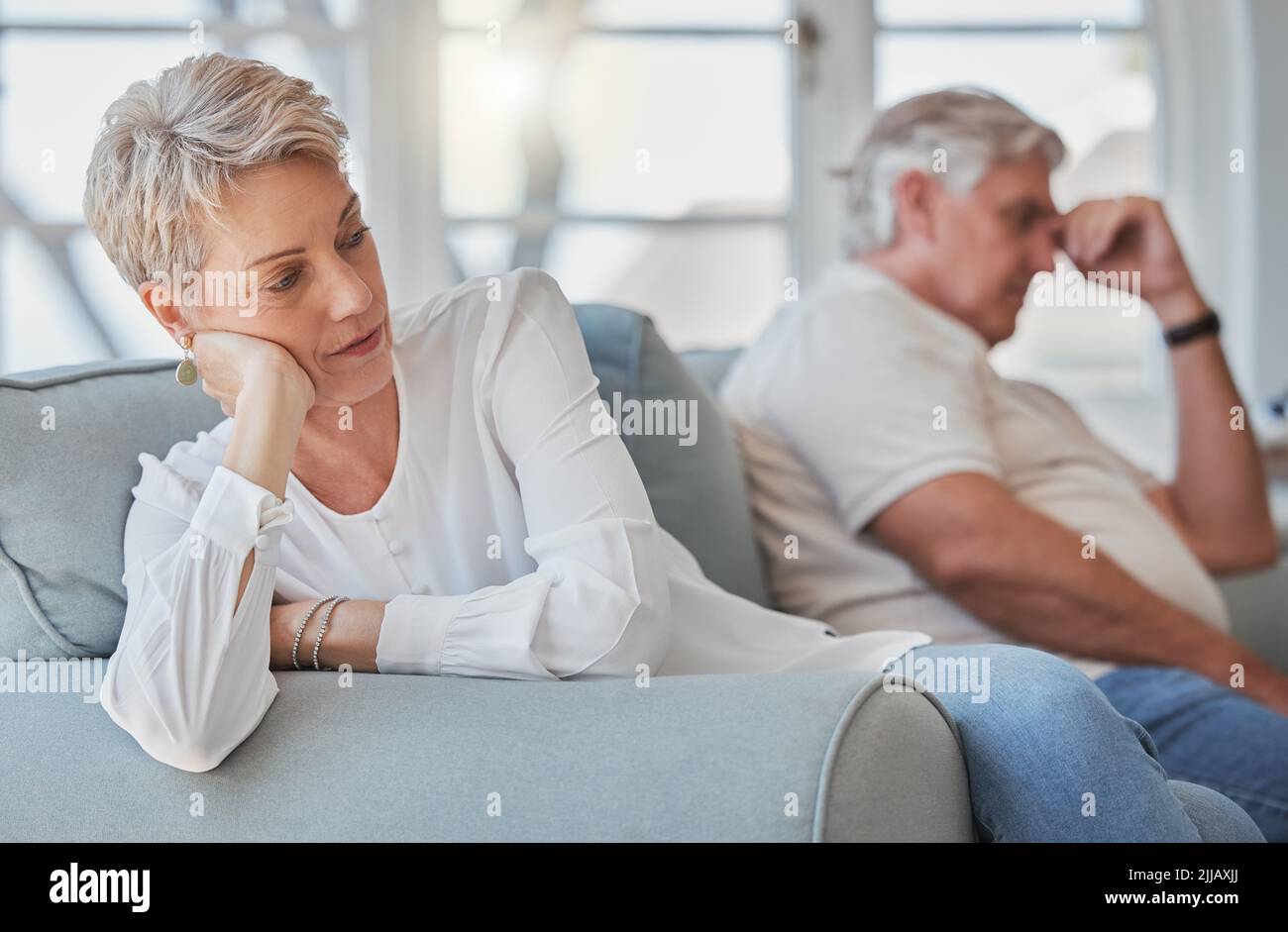 Odia i combattimenti, una coppia anziana che guarda triste e turbata mentre si siede nel loro salotto dopo un argomento. Foto Stock