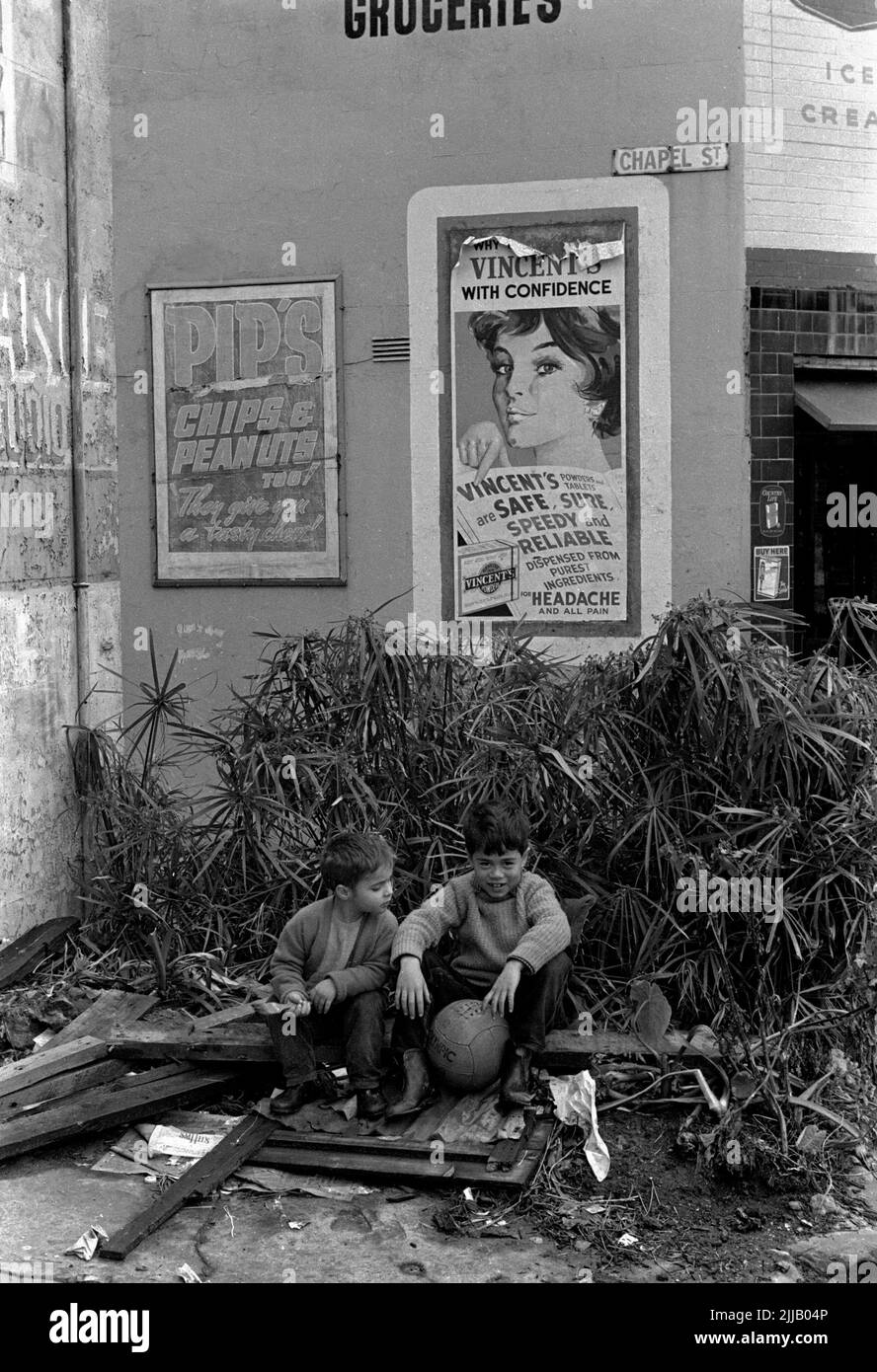 Street photography, bambini che giocano con la sfera di calcio sul lotto libero nella città interna di Sydney, 1962 Foto Stock