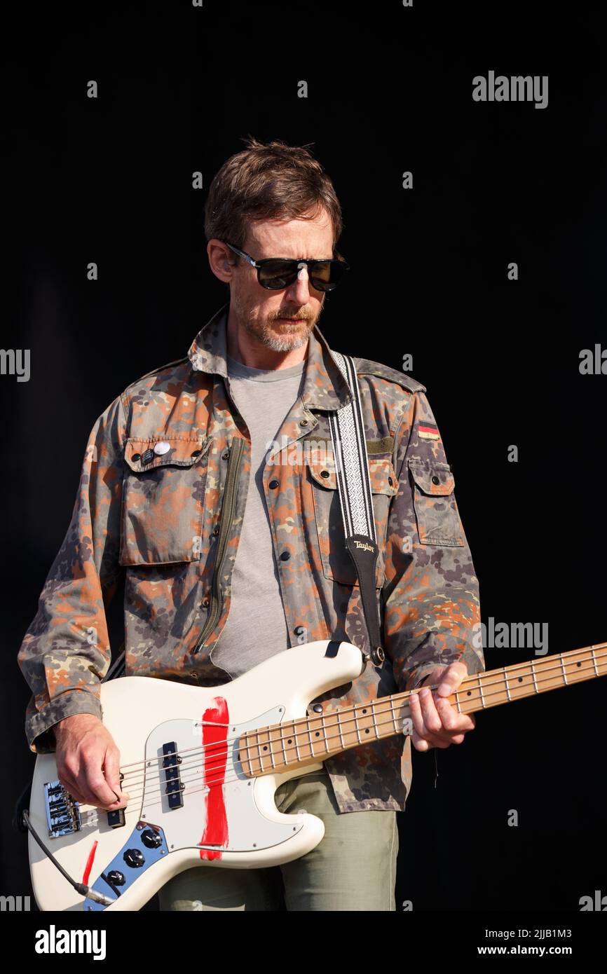 Il bassista James Hall gioca sul palco indossando una giacca camouflage e occhiali da sole Foto Stock