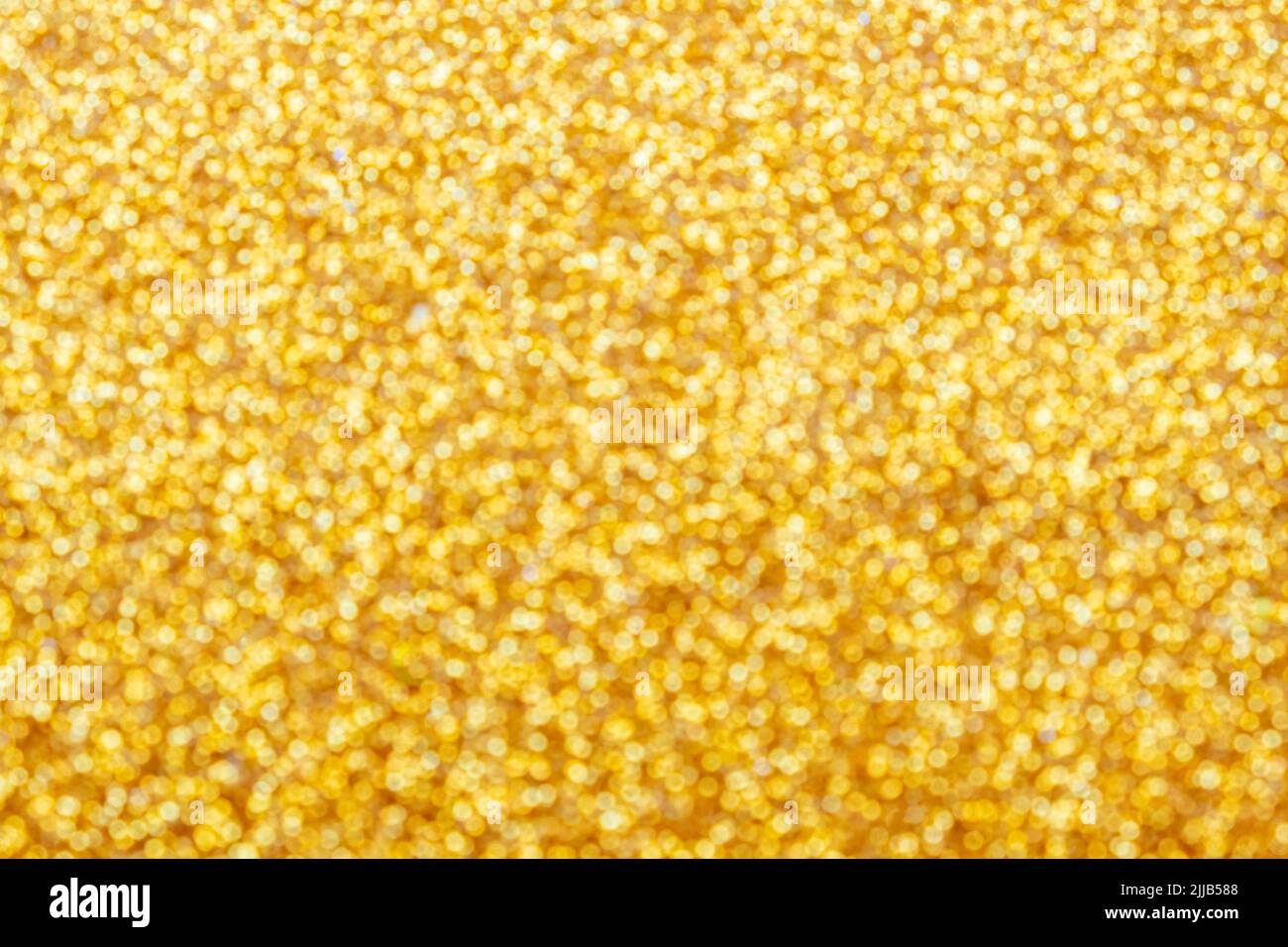 Oro chiaro brillante bokeh sfondo sfocato astratto con brillante sfocatura circolare motivo dorato. Foto Stock