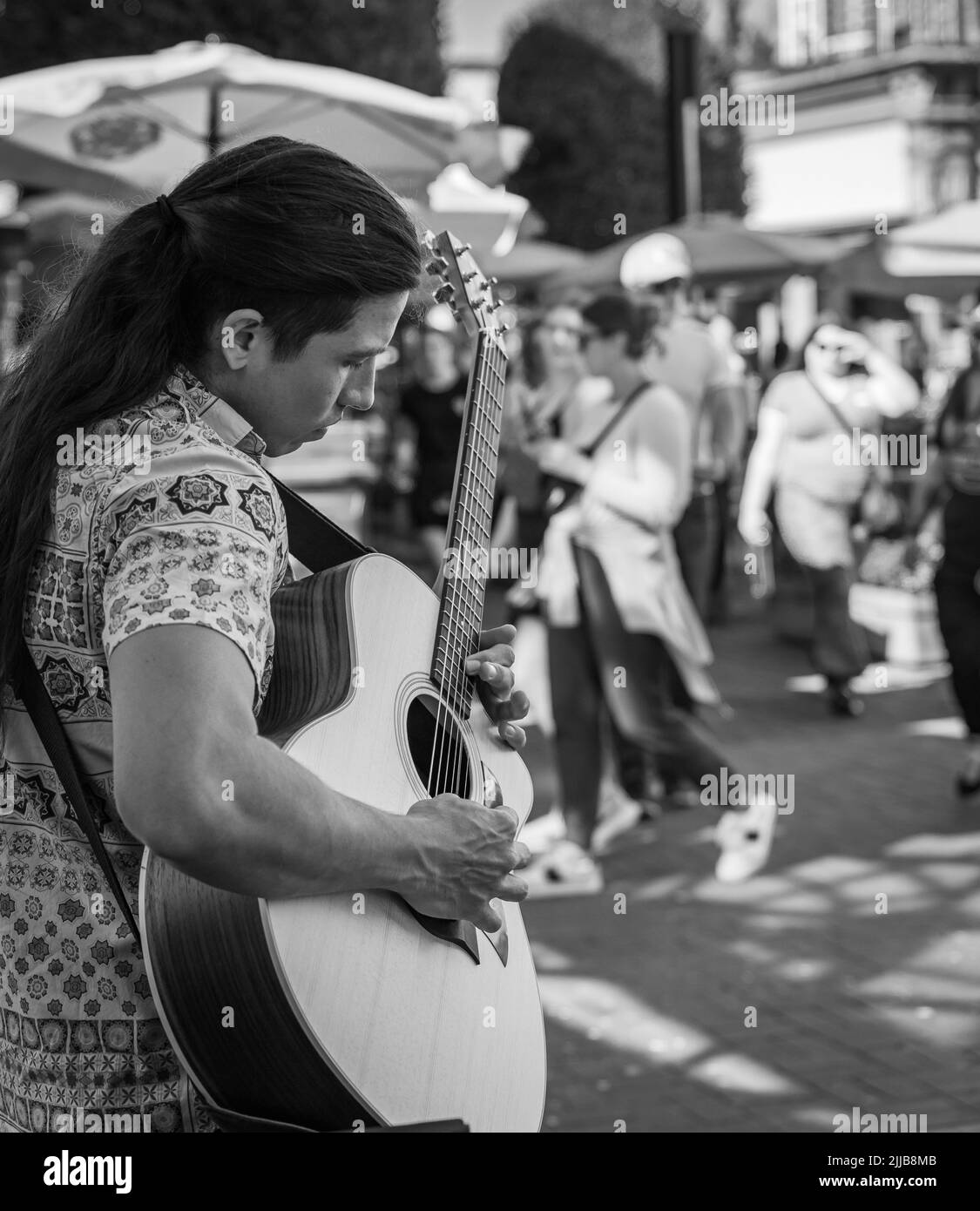 Un uomo romantico sta suonando la chitarra sulla strada della città. Un musicista di strada suona all'aperto. Amore, romanticismo, amanti, serenata, romanticismo, Foto di viaggio-luglio Foto Stock