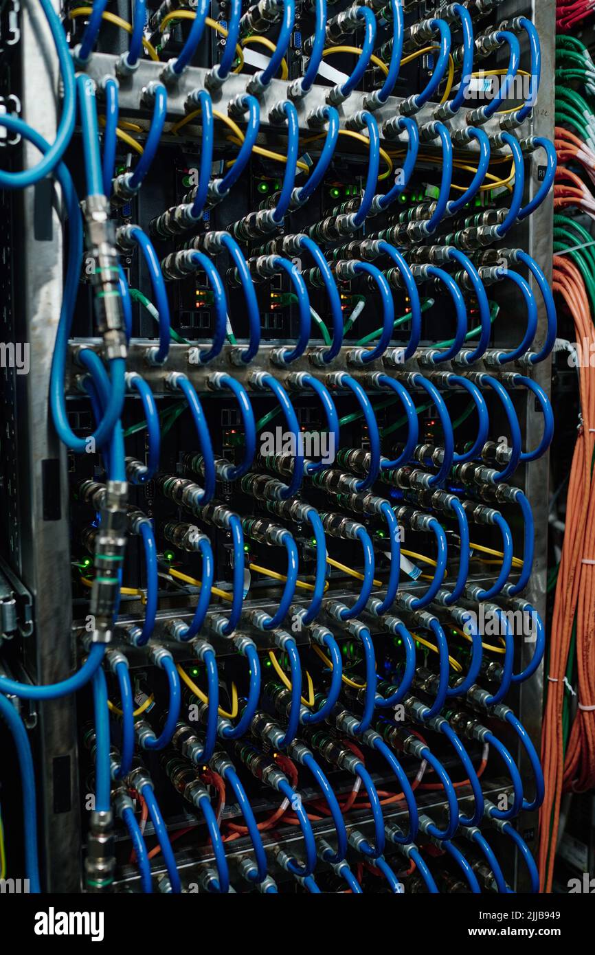 Primo piano dei cavi Internet collegati tra loro in un server aperto nel data center Foto Stock