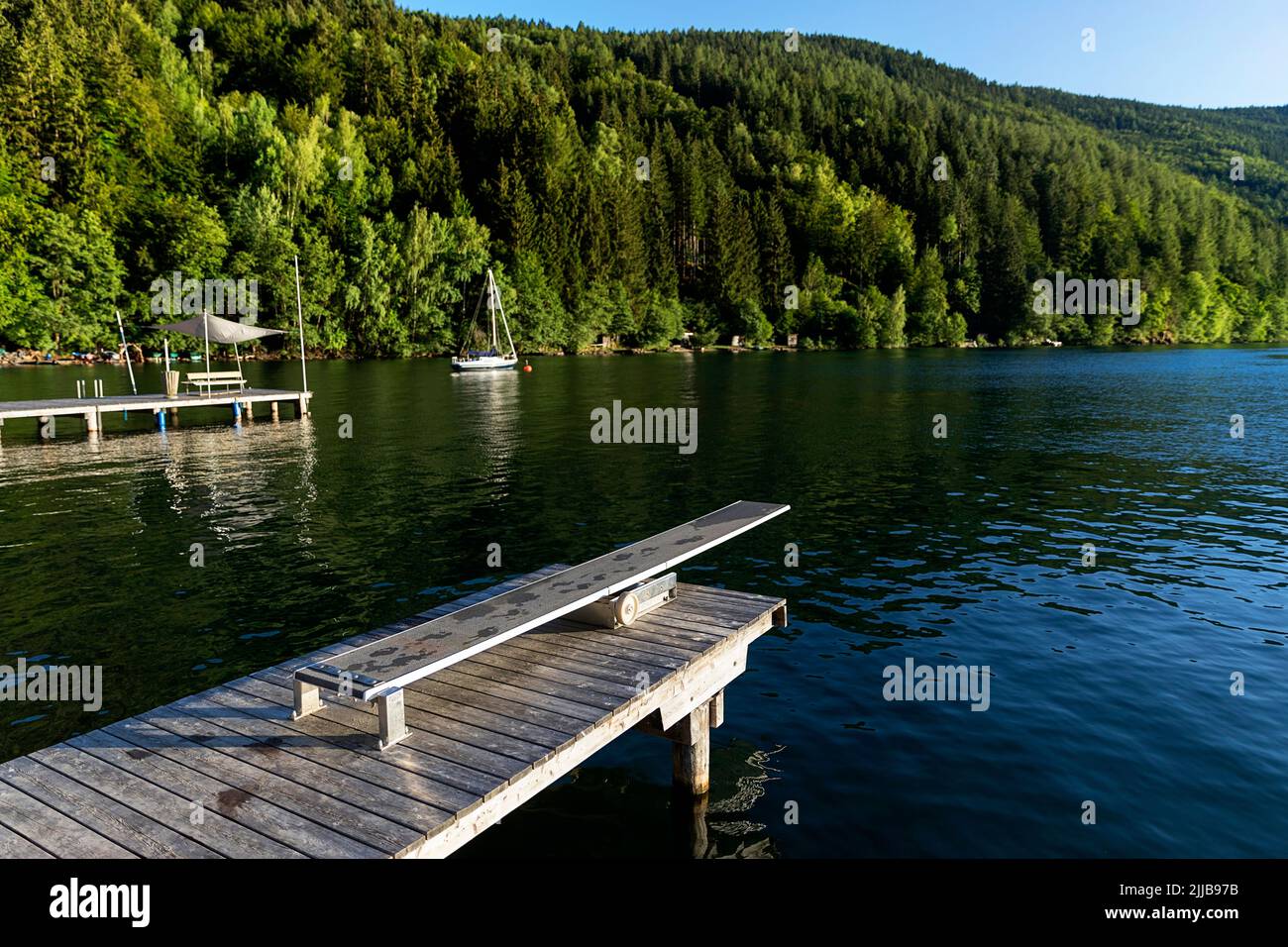 Piattaforma subacquea su un bellissimo molo in legno sul lago Millstätter See al tramonto, Carinzia, Austria Foto Stock