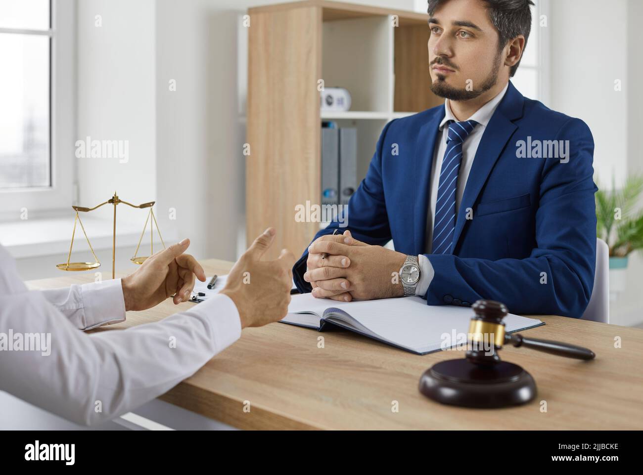 Professionista qualificato avvocato legale maschile conduce colloquio di consultazione con il cliente in carica. Foto Stock