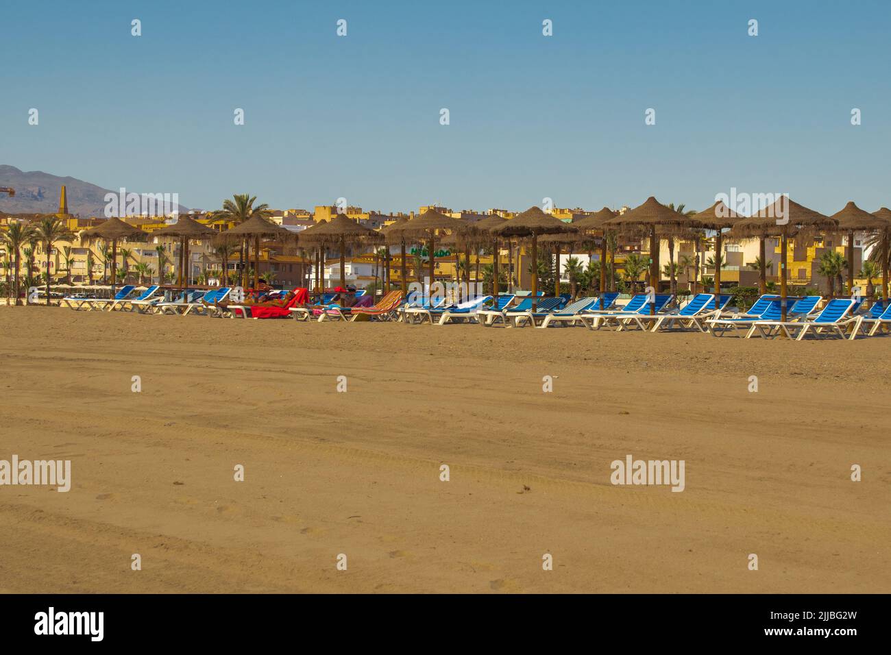 I bagnanti si godono il tempo soleggiato e le alte temperature su una tranquilla spiaggia di vera Garrucha, provincia di Almeria, Andalucía Spagna Foto Stock