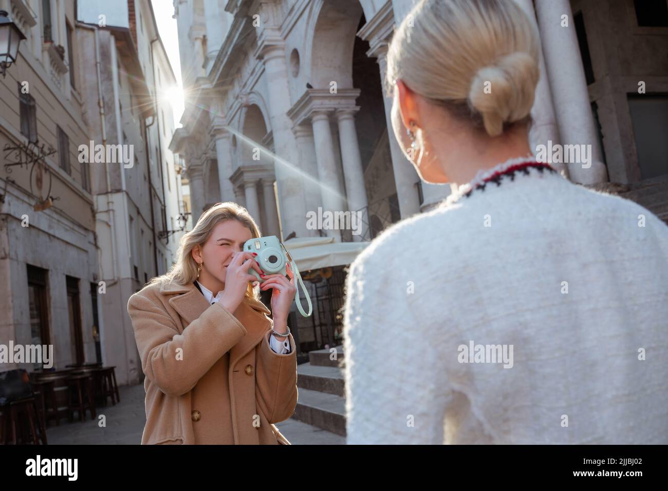 Fotografo concentrato che scatta foto di una donna Foto Stock