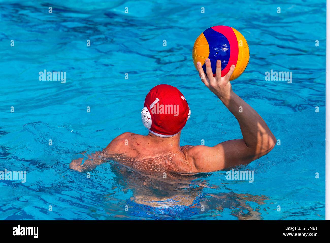 Waterpolo gioco nuotatore giocatore irriconoscibile dietro foto posteriore con palla in mano gioco azione primo piano . Foto Stock