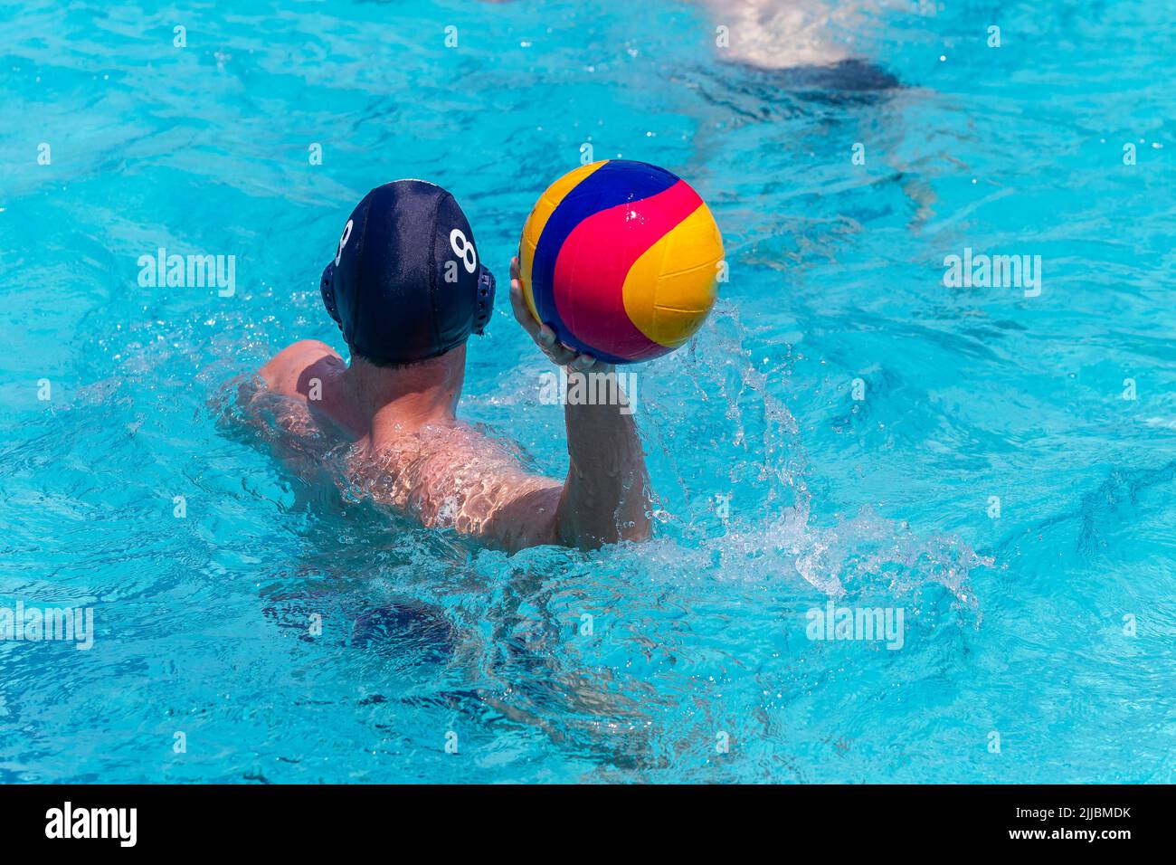 Waterpolo gioco nuotatore giocatore irriconoscibile dietro foto posteriore con palla in mano gioco azione primo piano . Foto Stock