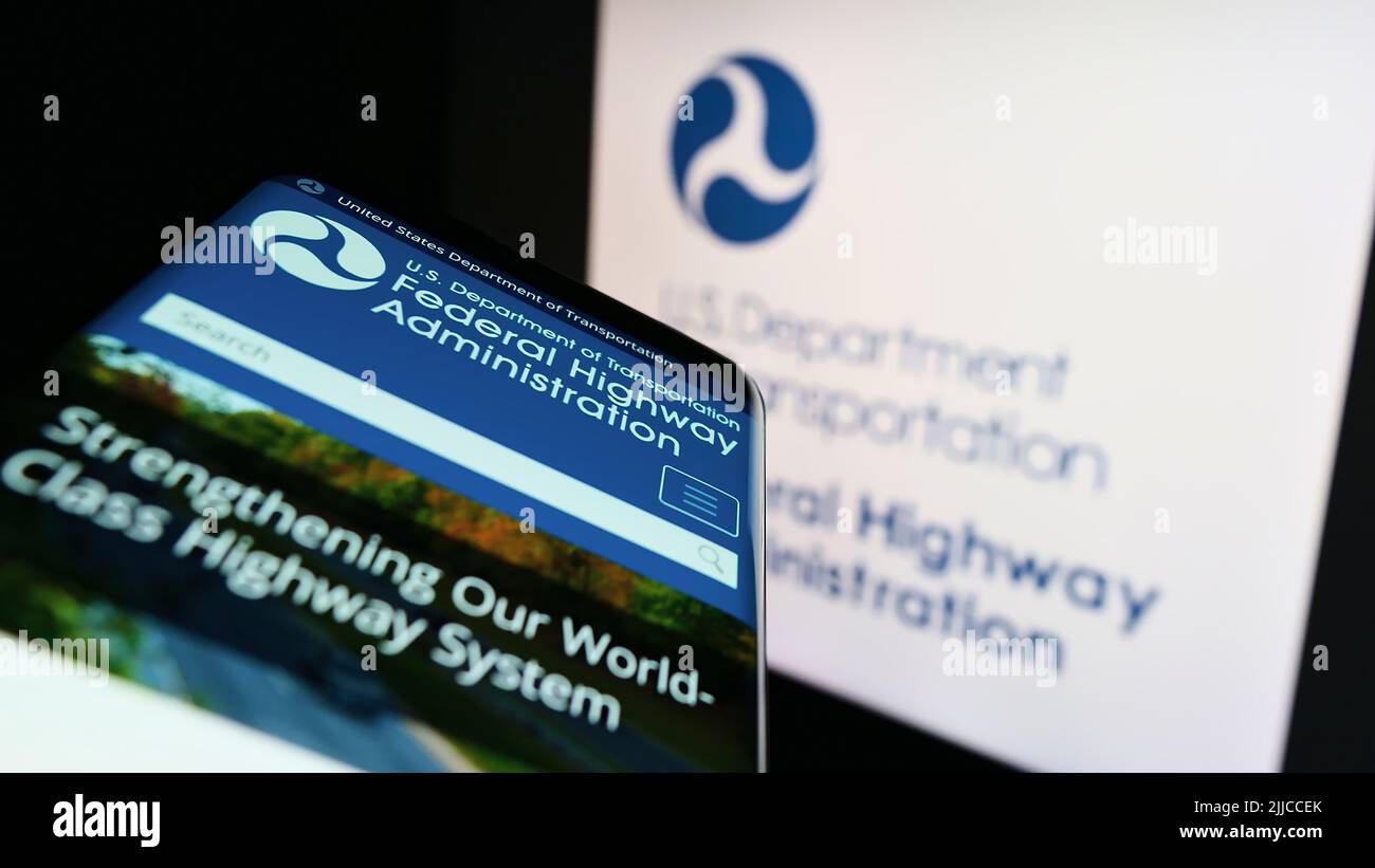 Telefono cellulare con pagina web della American Federal Highway Administration (FHWA) sullo schermo di fronte al logo. Mettere a fuoco sulla parte superiore sinistra del display del telefono. Foto Stock