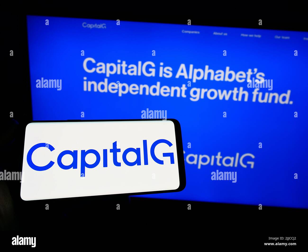 Persona che tiene smartphone con il logo dell'investitore americano CapitalG Management Company LLC sullo schermo di fronte al sito web. Mettere a fuoco sul display del telefono. Foto Stock