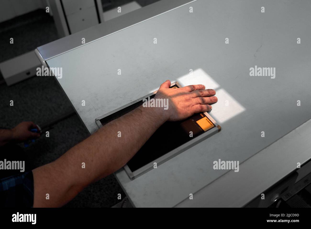 Mano del paziente sopra una piastra radiogena Foto Stock