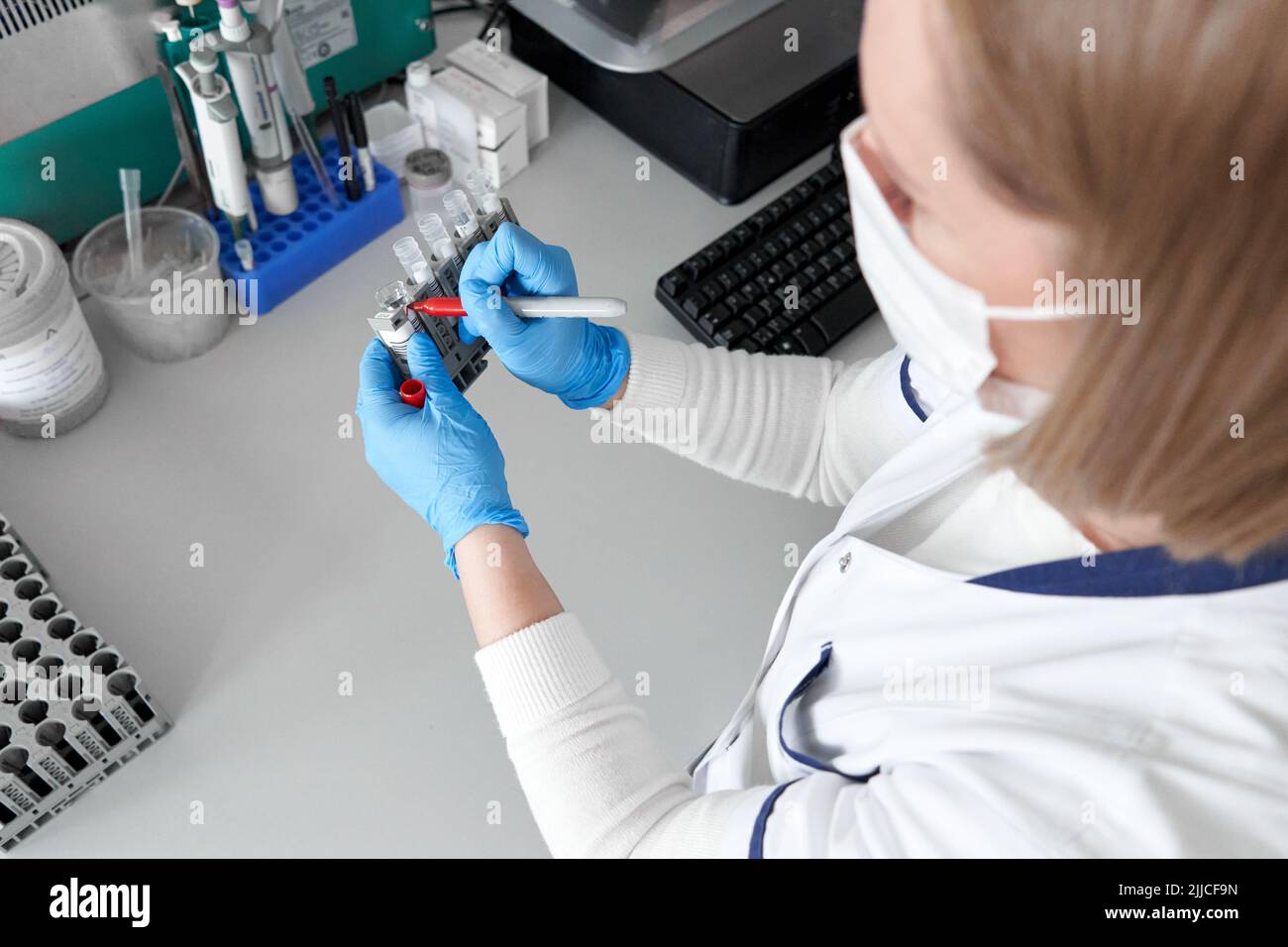 Il tecnico di laboratorio contrassegna alcuni campioni con un pennarello rosso Foto Stock