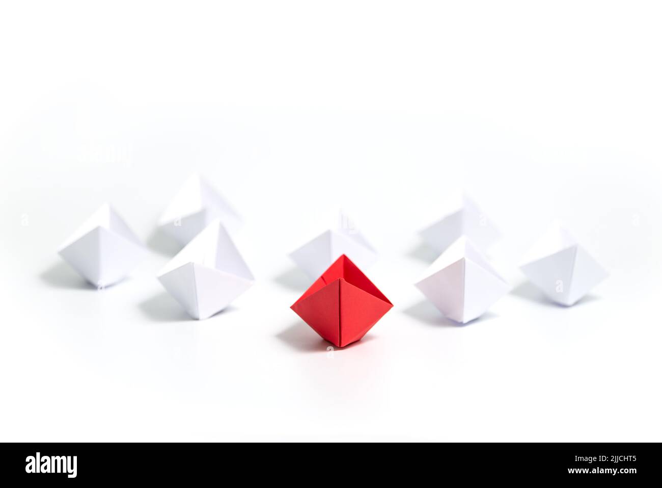 Barche di carta rossa e bianca. Concetto di barche di leadership per il gruppo di lavoro di squadra o il successo. Foto Stock