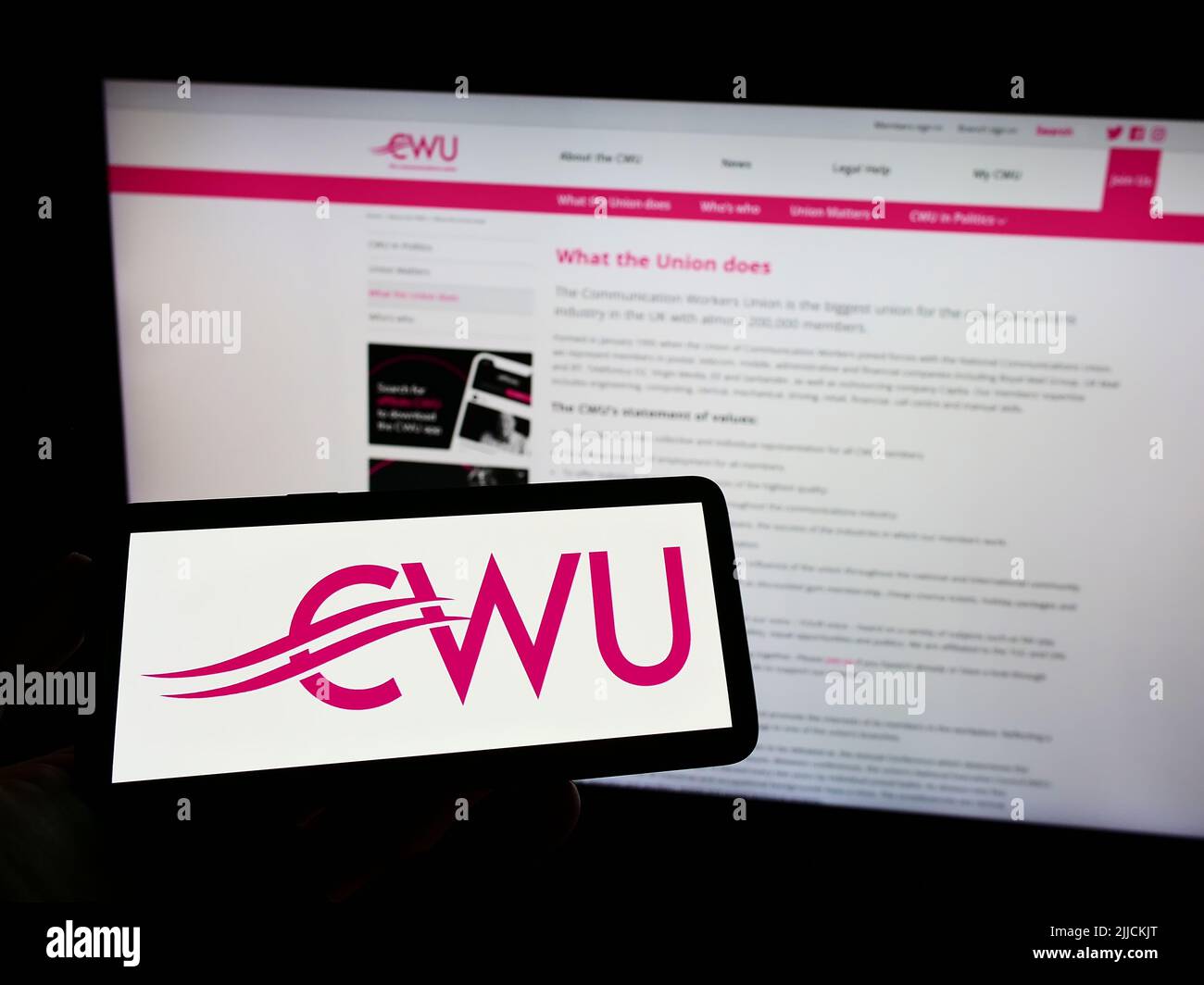 Persona che tiene il telefono cellulare con il logo della British Communication Workers Union (CWU) sullo schermo di fronte alla pagina web. Mettere a fuoco sul display del telefono. Foto Stock