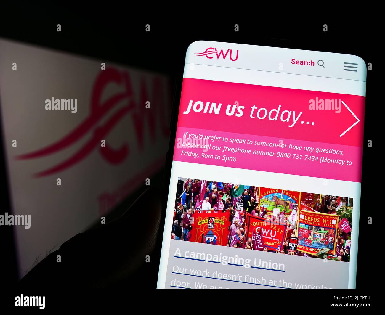 Persona che tiene il cellulare con pagina web della British Communication Workers Union (CWU) sullo schermo davanti al logo. Concentrarsi sul centro del display del telefono. Foto Stock