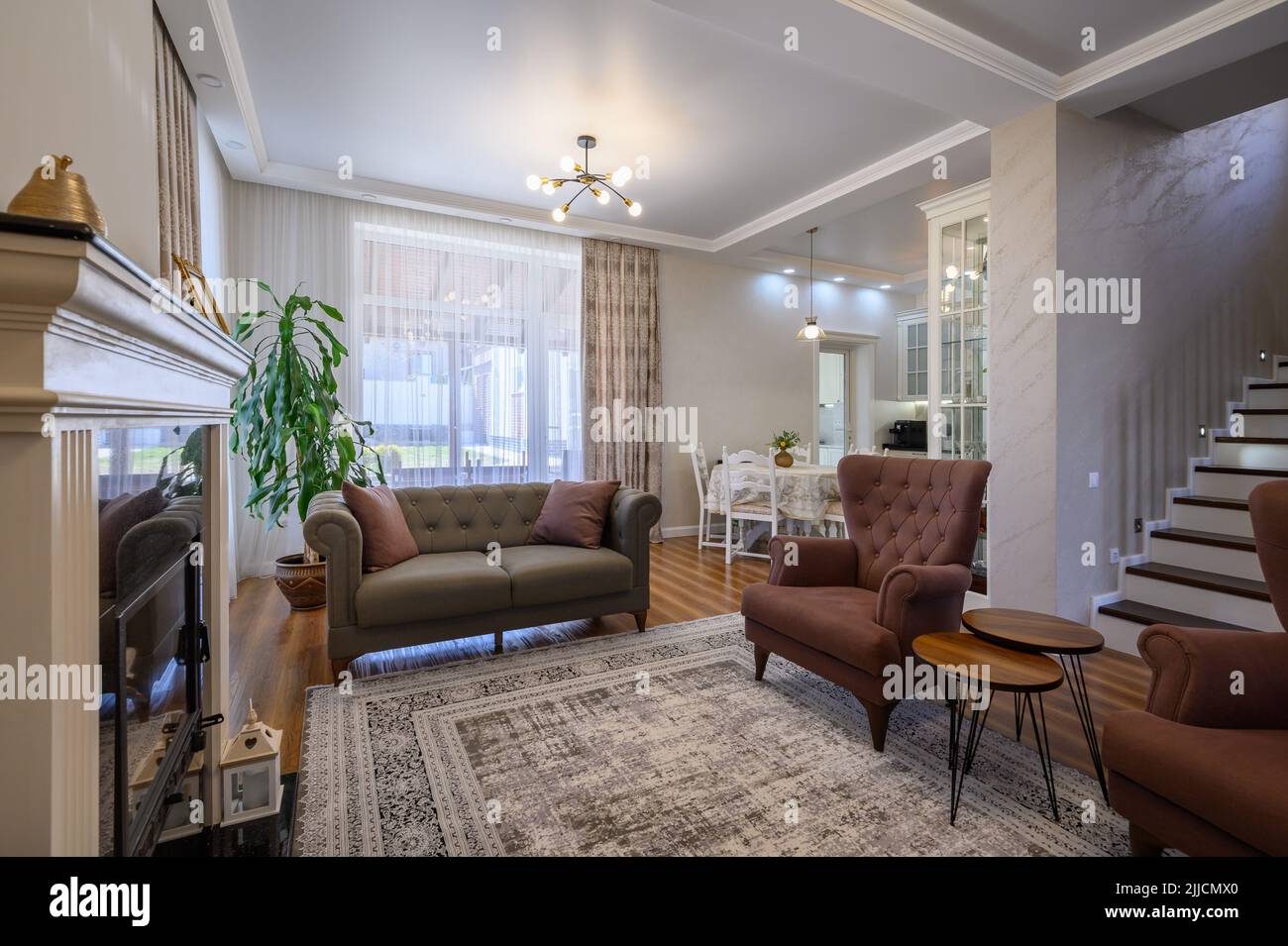 Appartamento monolocale con soggiorno con grande cucina bianca e tavolo da pranzo Foto Stock