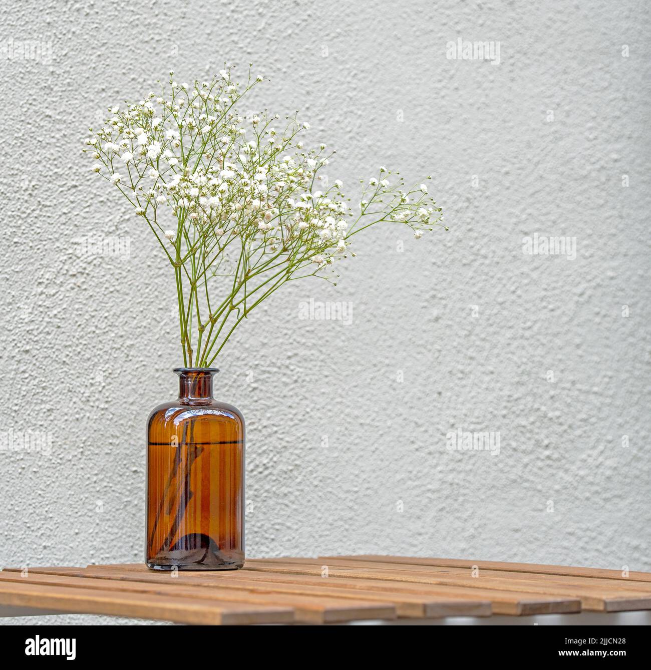 Still Life con una composizione floreale minima su un tavolo di legno in un caffè di strada Foto Stock