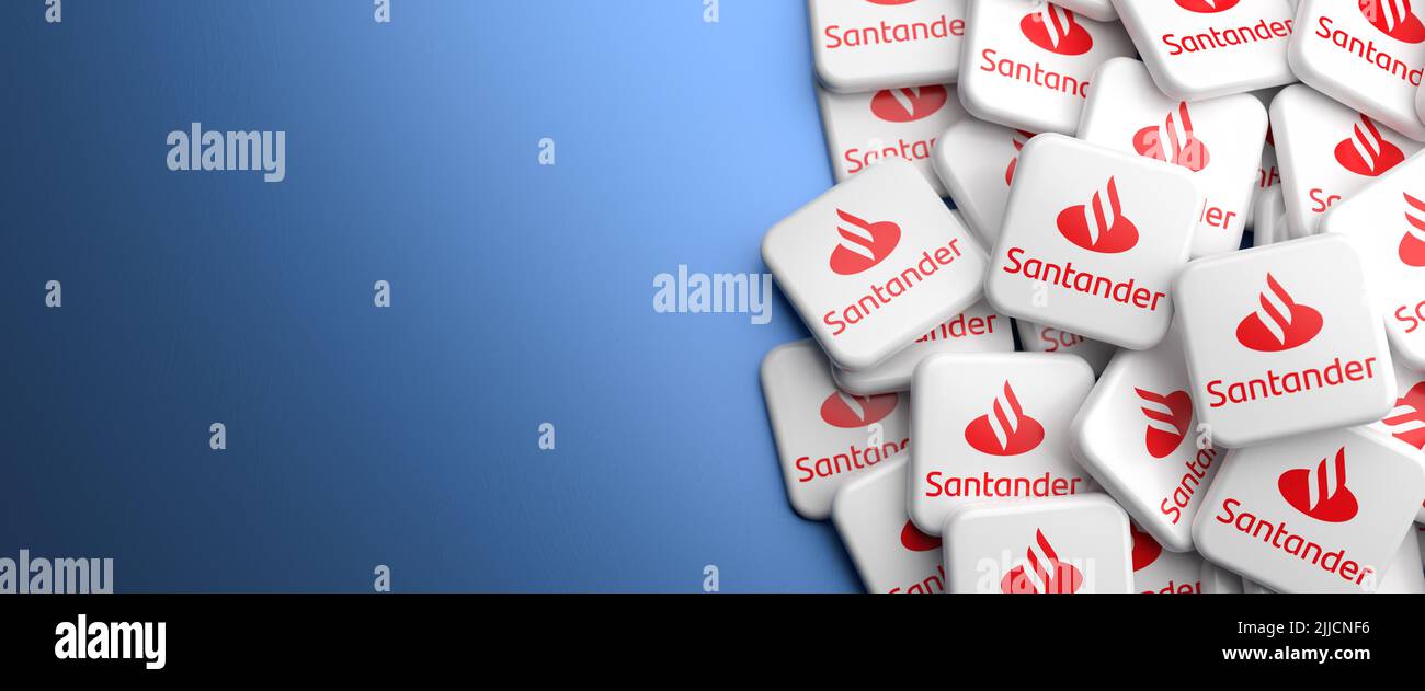 Logo della società spagnola di servizi bancari e finanziari Banco Santander su un mucchio su un tavolo. Spazio di copia. Formato banner Web. Foto Stock