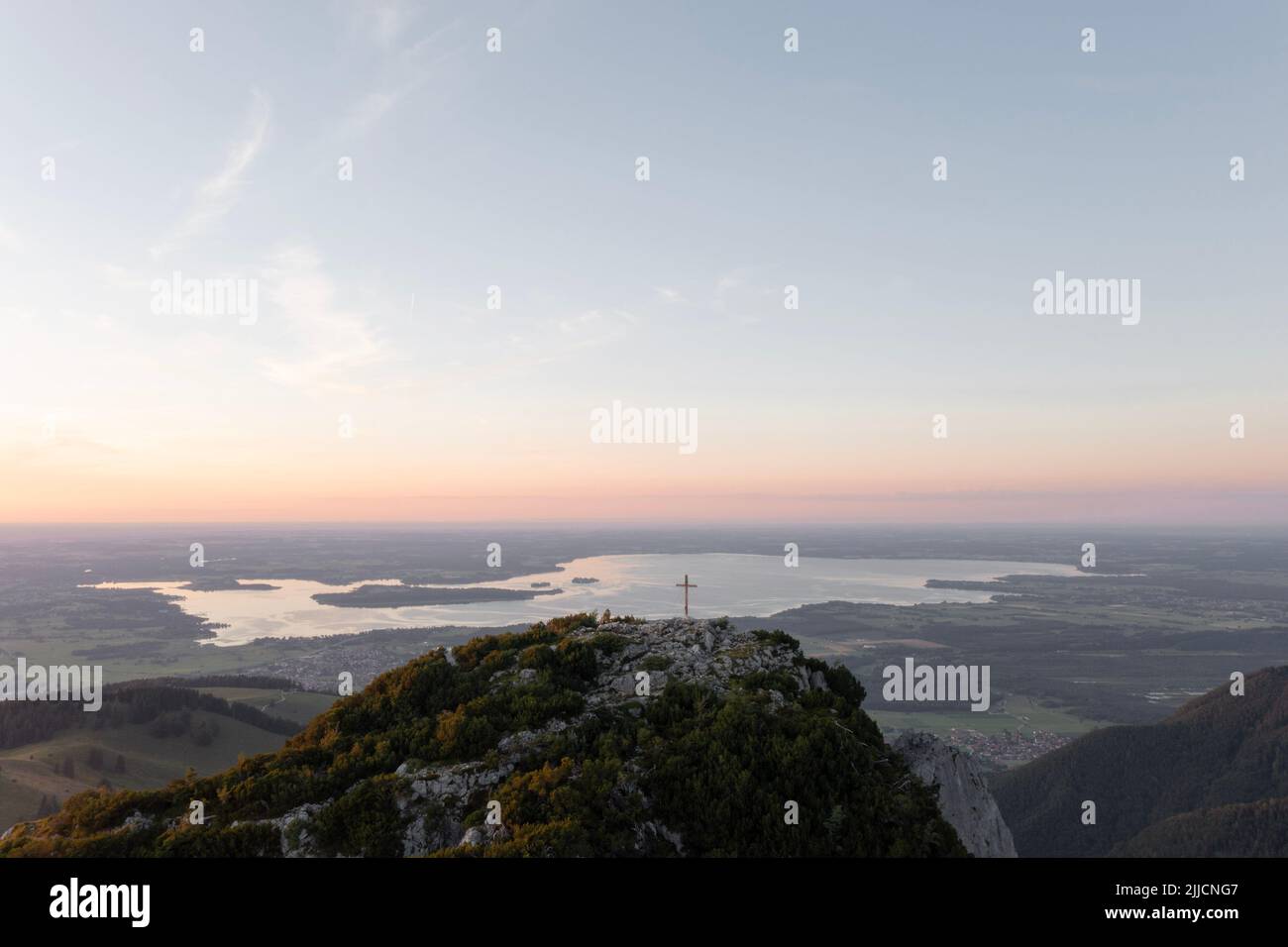 Die Gedererwand. Die kleine Schwester der Kampenwand. Das Gipfelkreuz an der Gederwand mit dem Blick über den Chiemsee bei Sonnenuntergang Foto Stock