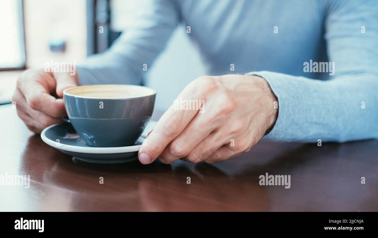 uomo mano tenere tazza caffè caffeina dipendenza abitudine Foto Stock