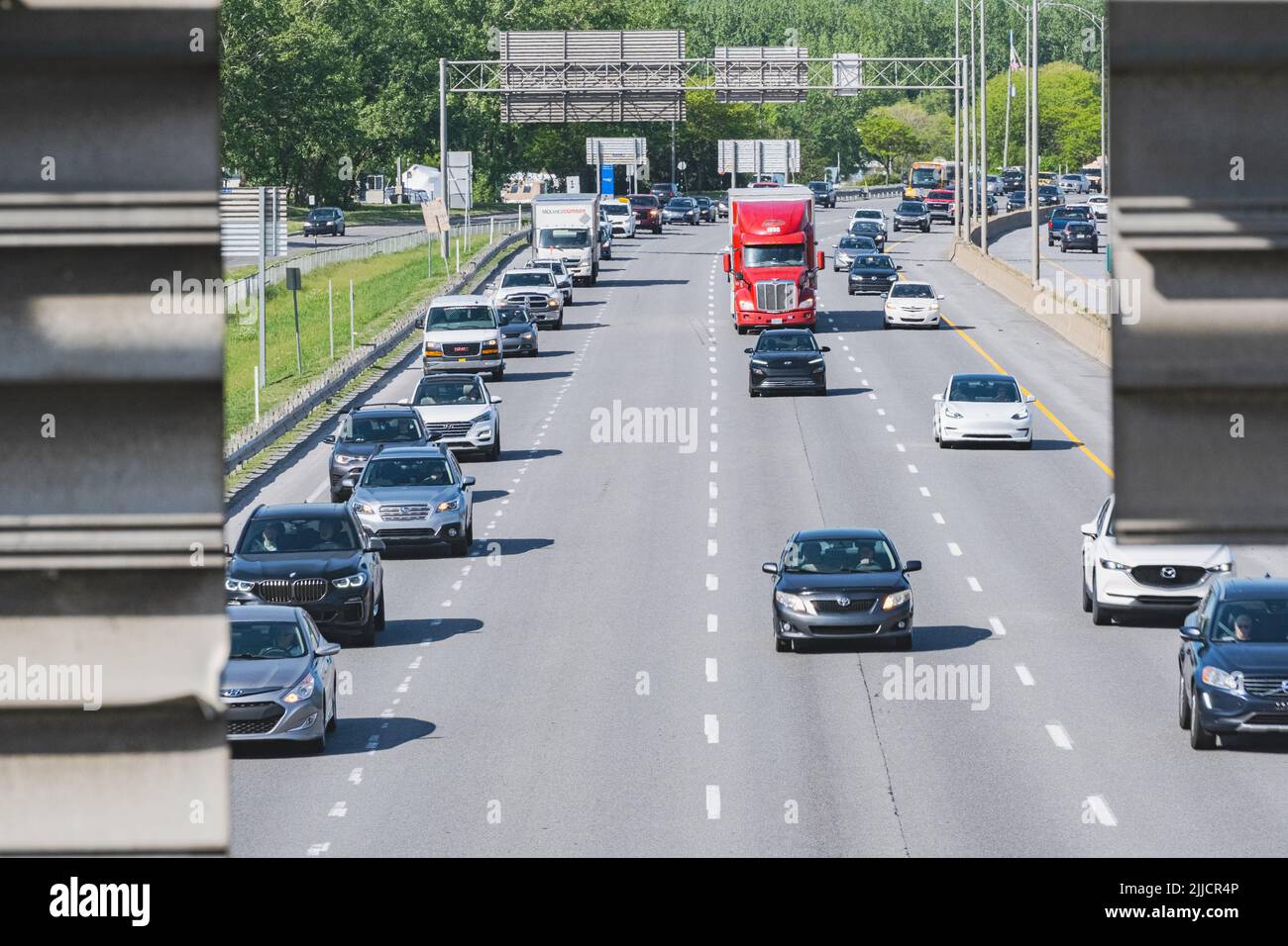 Le auto durante le ore di punta del traffico divergono per prendere la loro uscita o rimanere sull'autostrada. Foto Stock