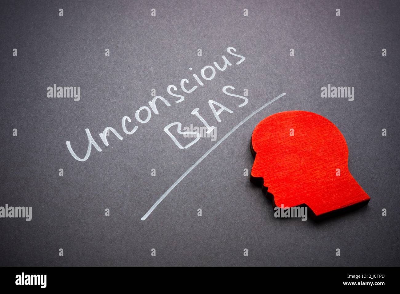 Firma il bias inconscio sulla superficie scura e sulla forma della testa. Foto Stock