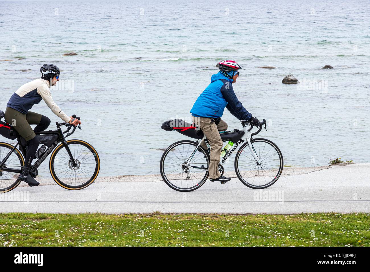 Domenica mattina i ciclisti lungo la costa a Visby, sull'isola di Gotland, nel Mar Baltico al largo della Svezia Foto Stock