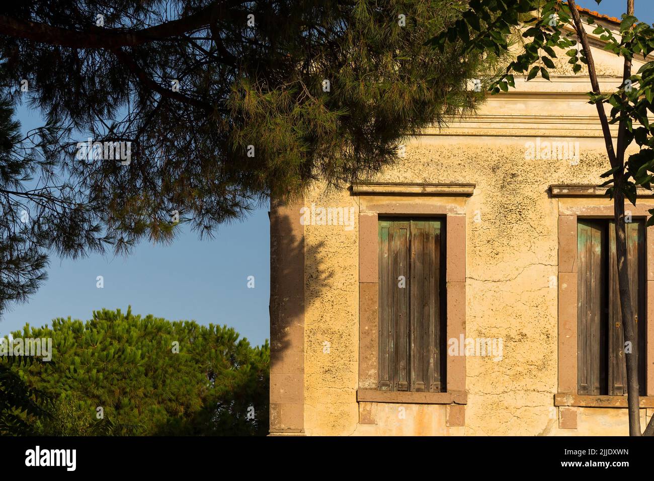 Vista di vecchia, storica, tradizionale casa in pietra che riflette il mar Egeo, stile architettonico mediterraneo catturato a Ayvalik, Turchia. È un'estate soleggiata Foto Stock