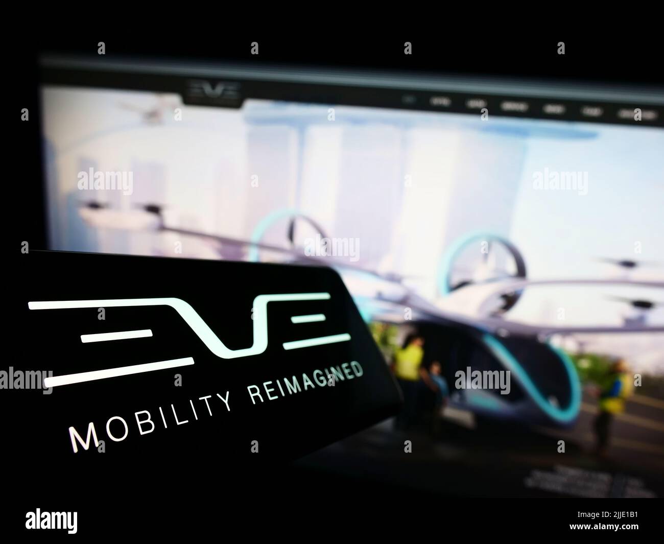 Telefono cellulare con il logo della società Eve Holding Inc. (Eve Air Mobility) sullo schermo di fronte al sito Web aziendale. Mettere a fuoco sulla sinistra del display del telefono. Foto Stock
