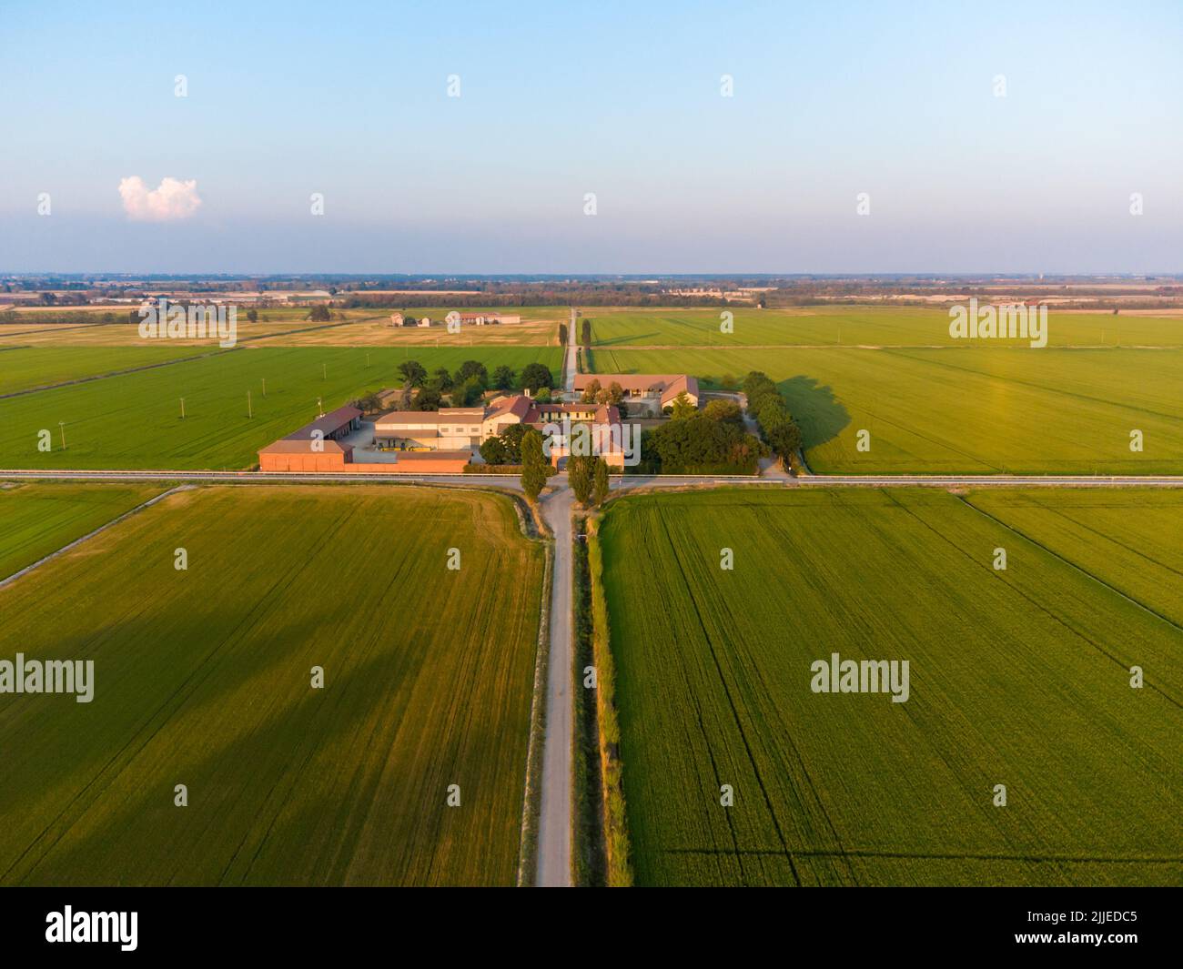 Paesaggio di campagna aerea in Italia con risaie e un antico edificio rurale Foto Stock