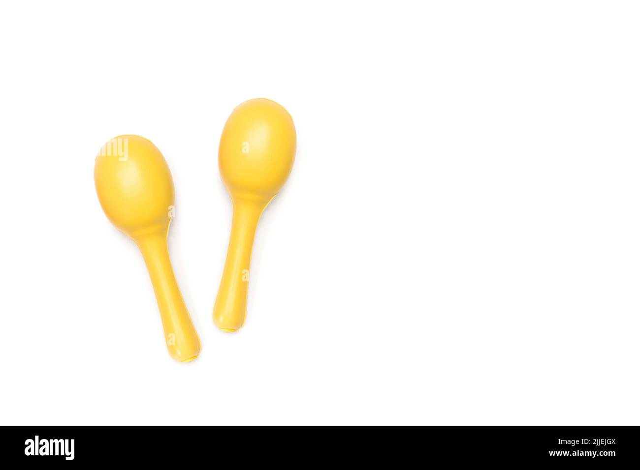 Due maracas gialle su sfondo bianco con spazio di copia Foto Stock