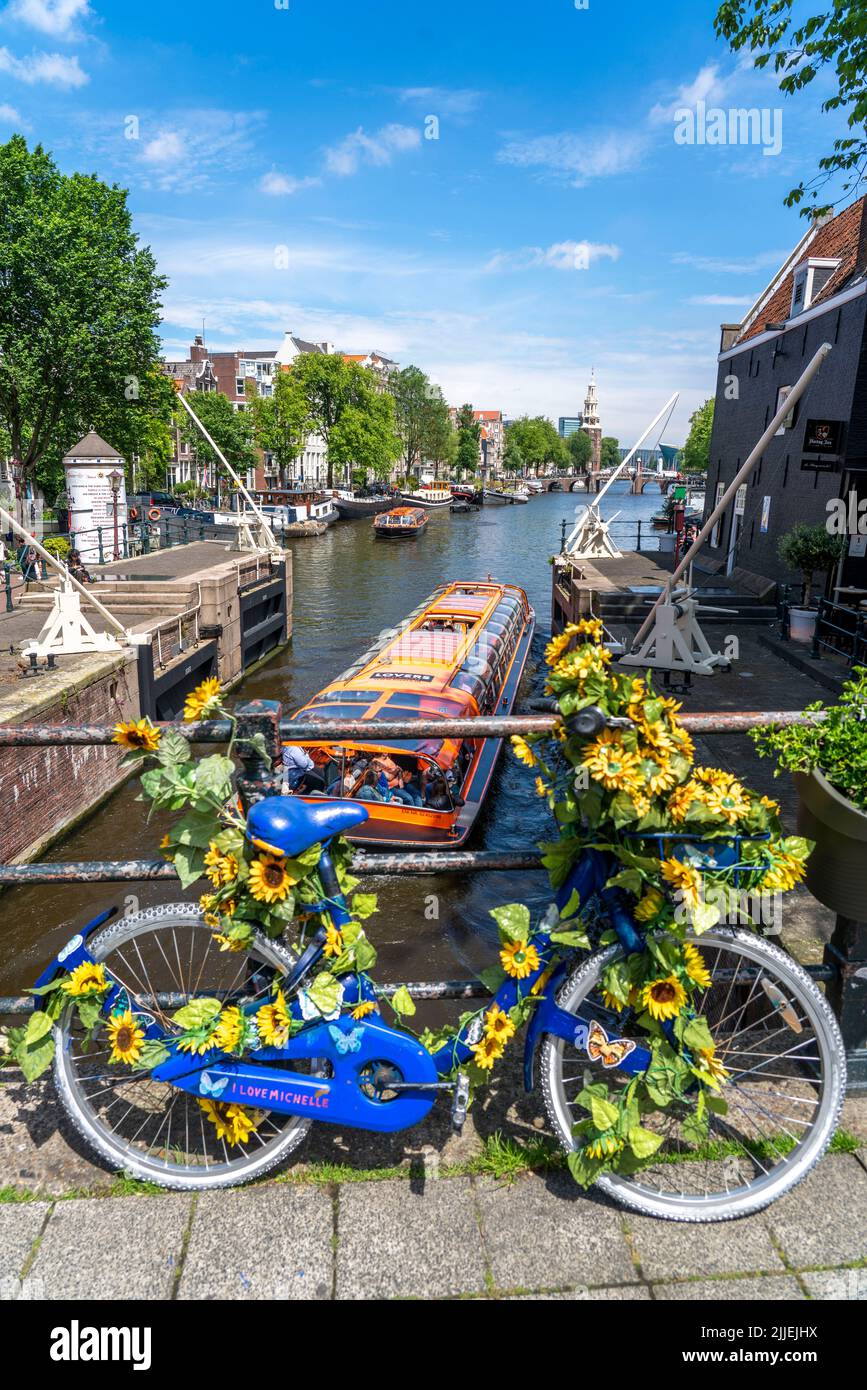 Sint Antoniesluis, sul canale Oudeschans, bicicletta decorata con girasoli, barca da crociera sul canale, café, De Sluyswacht, Amsterdam, Paesi Bassi Foto Stock