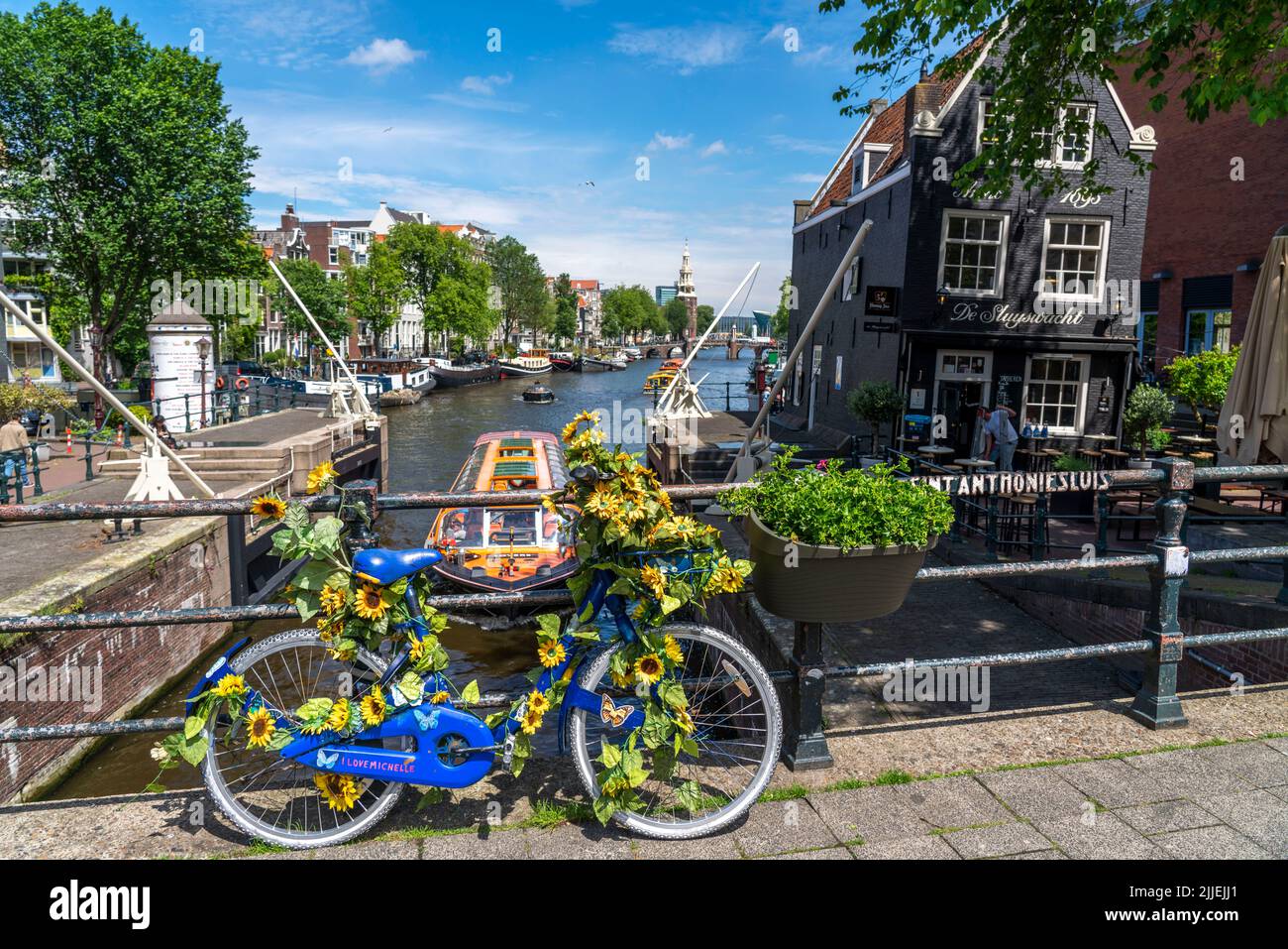 Sint Antoniesluis, sul canale Oudeschans, bicicletta decorata con girasoli, barca da crociera sul canale, café, De Sluyswacht, Amsterdam, Paesi Bassi Foto Stock
