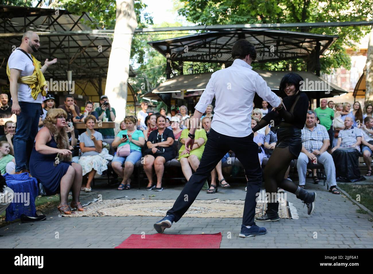 Il pubblico guarda come attori teatrali eseguire 'Odessa, io ti amo' al mercato del libro a Odessa. Lo spettacolo 'Odessa, ti amo' racconta storie della vita degli abitanti di Odessa con il suo caratteristico colore e umorismo. Lo spettacolo è stato organizzato dagli attori del Teatro n° 7 e giocato all'aperto al mercato del libro. L'obiettivo della performance è quello di aumentare le donazioni per le esigenze di difesa aerea. Foto Stock