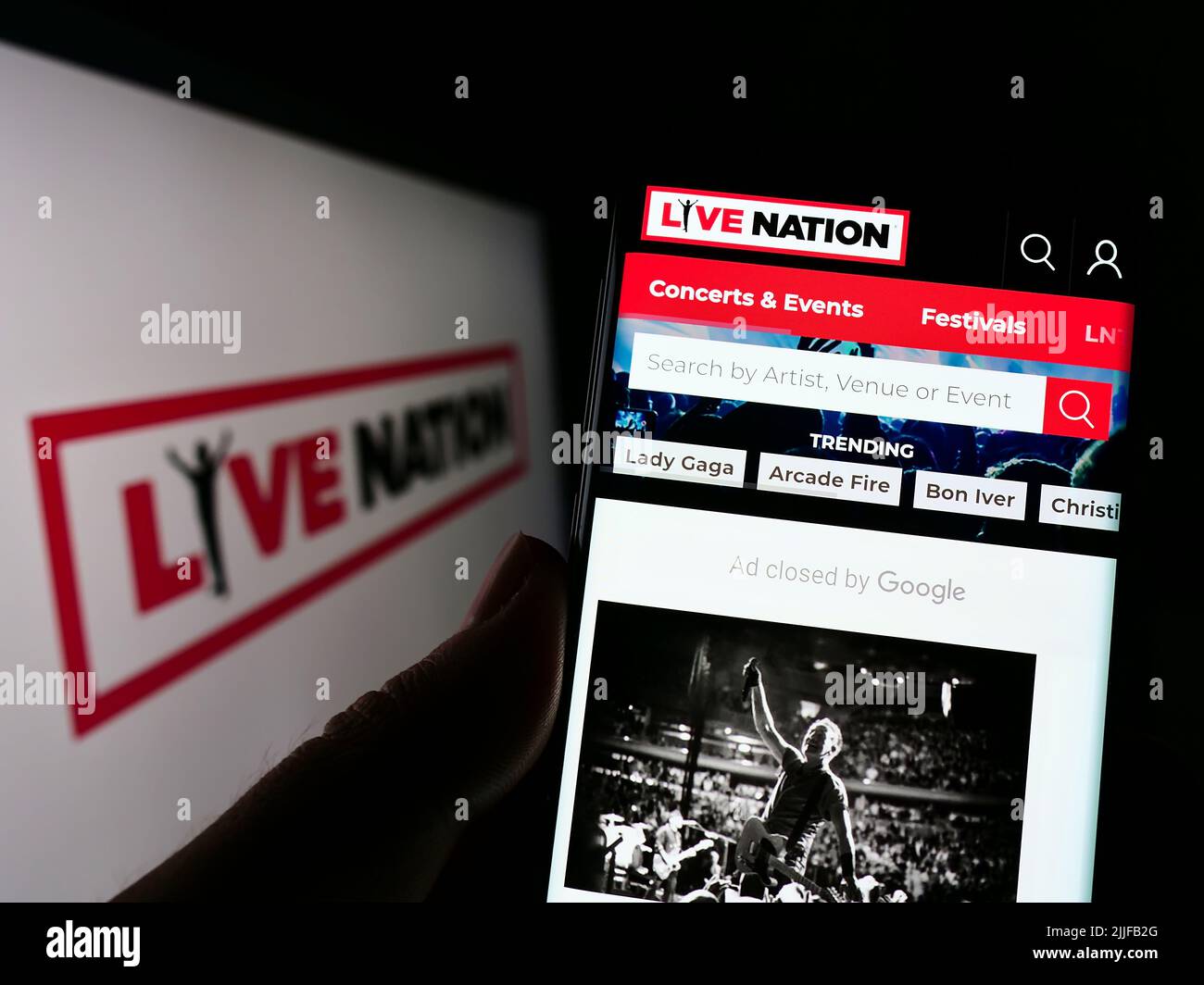 Persona che detiene la cellulare con la pagina web della società statunitense Live Nation Entertainment Inc. Sullo schermo di fronte al logo. Concentrarsi sul centro del display del telefono. Foto Stock