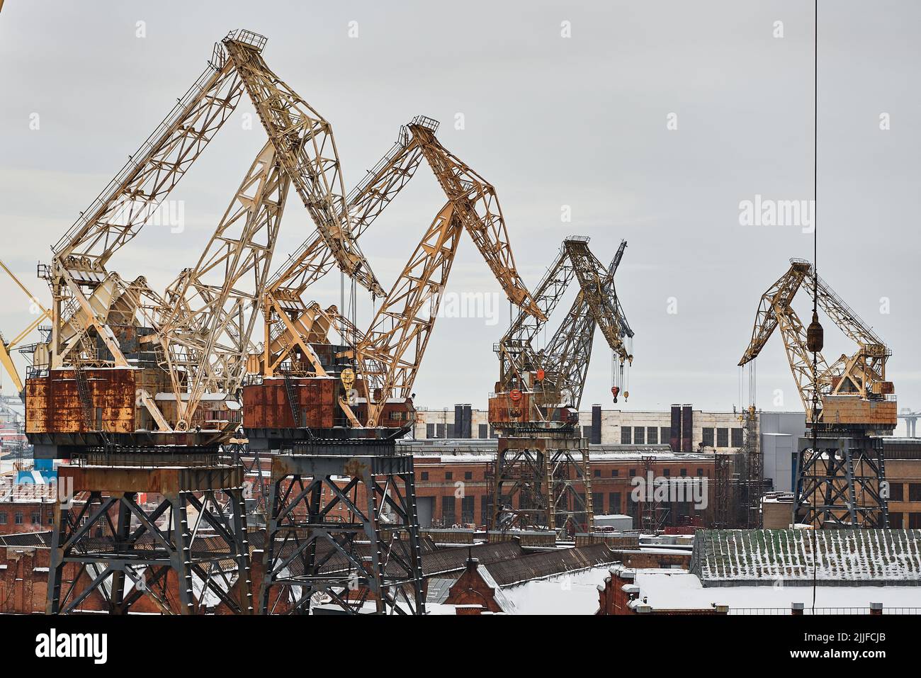 Gruppo di gru a portale in cantiere di porto sotto cielo nuvoloso Foto Stock