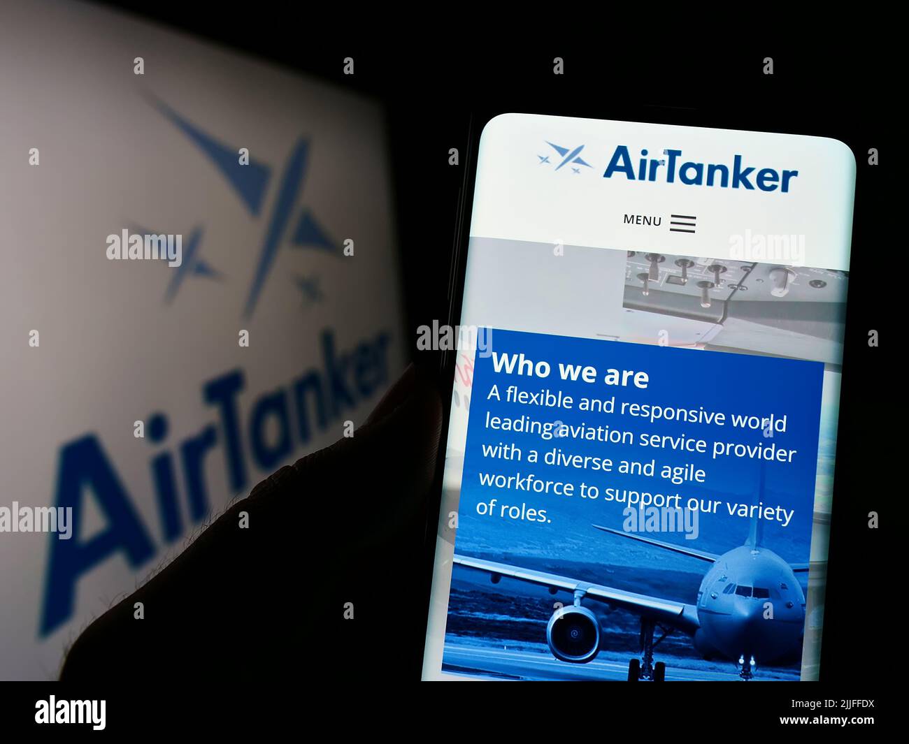 Persona che detiene il cellulare con il sito web della società britannica AirTanker Services Limited sullo schermo di fronte al logo. Concentrarsi sul centro del display del telefono. Foto Stock