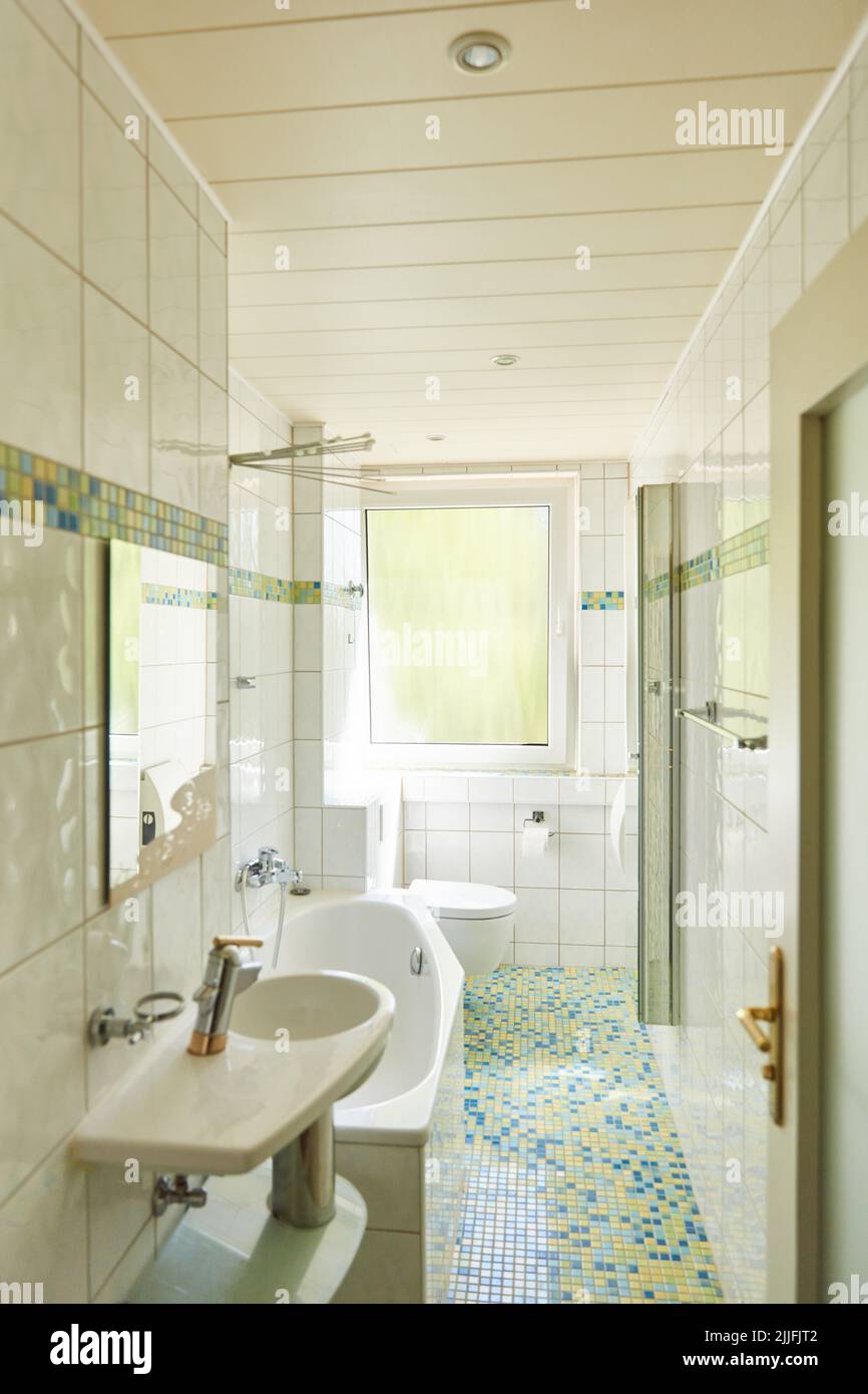 Bagno piccolo, stretto e luminoso con vasca in appartamento Foto Stock