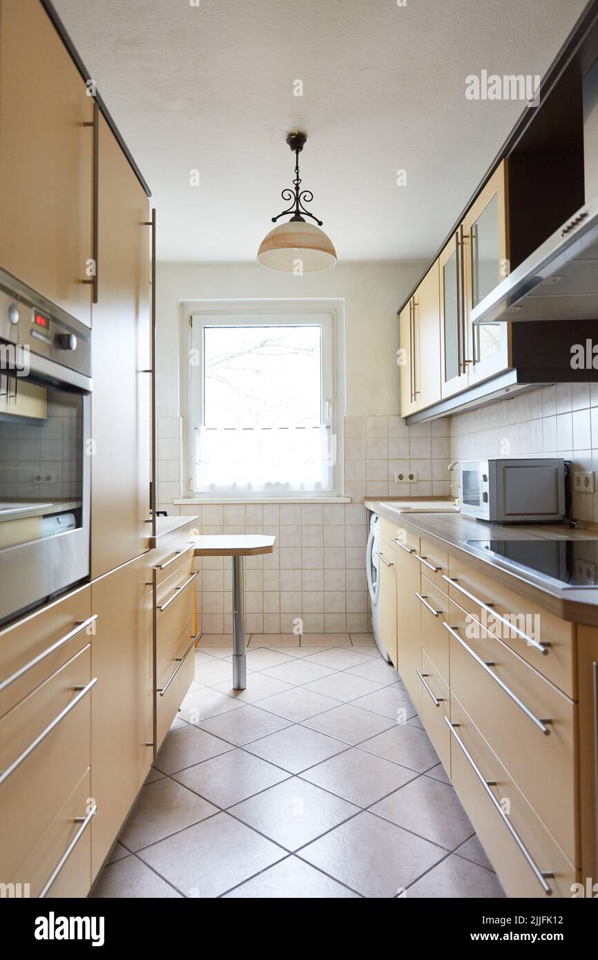 Cucina stretta con angolo cottura beige in una camera di un appartamento Foto Stock