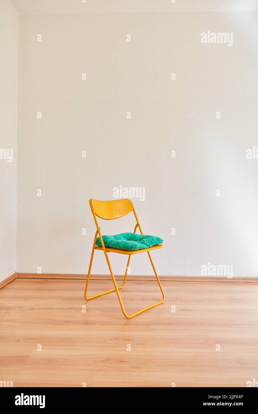 Sedia vuota con cuscini per l'attesa nella stanza vuota di un appartamento Foto Stock